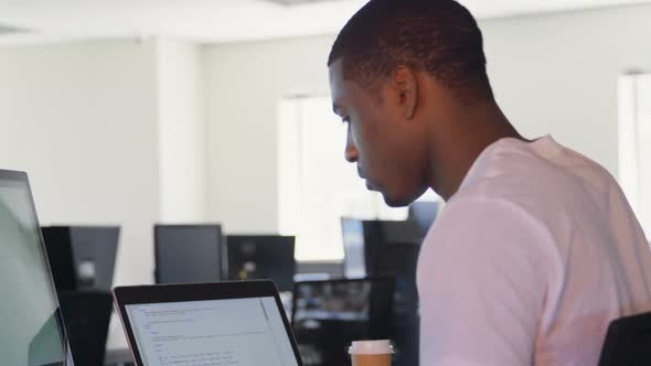 Side view of young black male executive working at desk in office 4k
