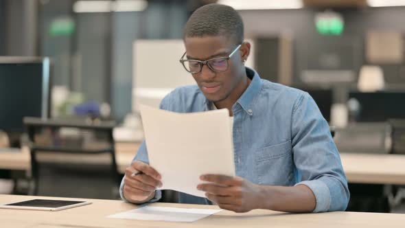 Young African American Man Upset By Loss on Documents