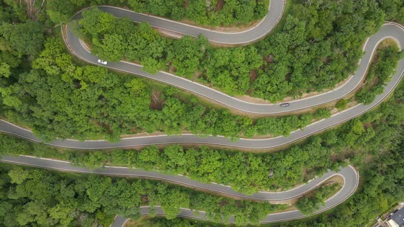 Cars driving along a steep mountain road with several hairpin turns during summer in Germany. Aerial