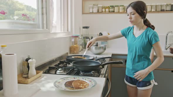 Young kids preparing pancakes in the kitchen using a frying pan