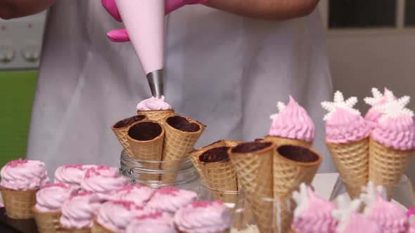 A Woman Fills Waffle Cones With Marshmallows. With A Pastry Bag. Medium Plan.