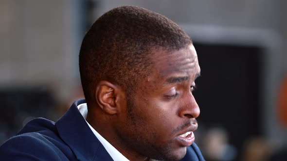 African American man in suit discussing with colleagues in loft