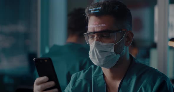 Male Doctor Unlocking Smartphone with Face Scan