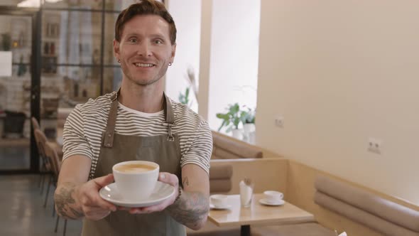 Caucasian Male Barista Offering Coffee