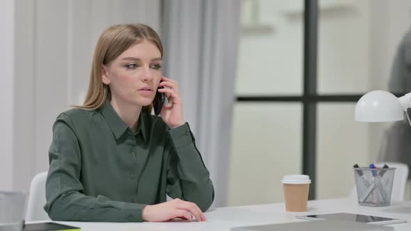 Young Woman Talking on Smartphone at Work