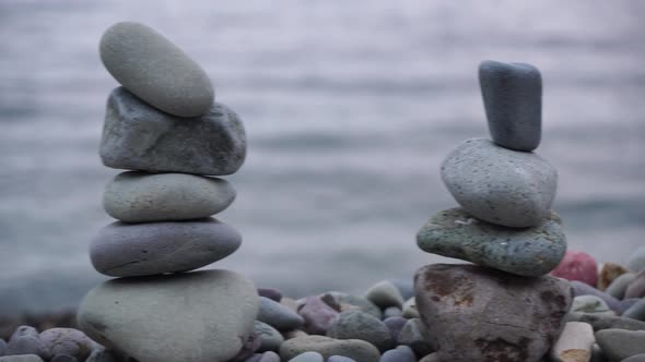 Balanced Pebble Pyramid on the Beach on a Sunset Time