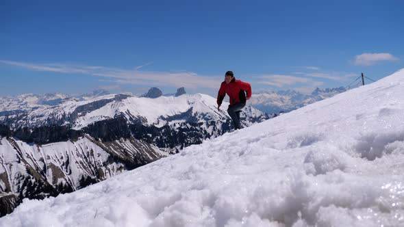 Young Man on the Top of the Alpine Mountains Jumps and Rejoices the Goal