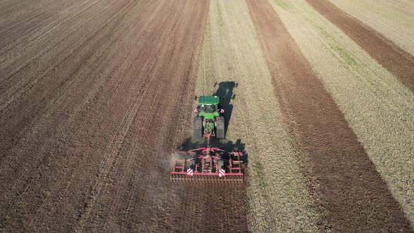 Birds Eye Aerial View of Tractor Plowing Land in Big Agricultural Farming Field on Sunny Morning, Dr