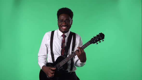 Portrait of Young African American Man Smiling and Playing Electric Guitar