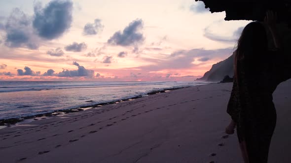 2.7K Girl Looks at Sunset on the Bali Hidden Beach Aerial