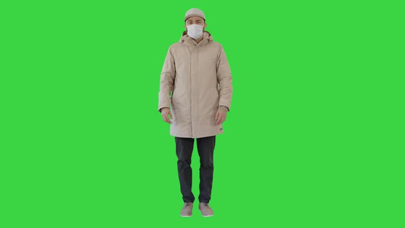 Young Man in Flu Mask Standing Doing Nothing on a Green Screen, Chroma Key