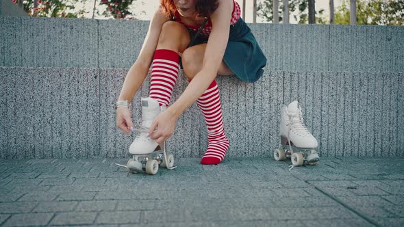 Close Up of Unrecognizable Lady in Bright Clothes Putting on Roller Skates Tying Shoelaces Preparing