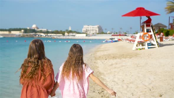 Little Happy Funny Girls Have a Lot of Fun at Tropical Beach Playing Together. Sunny Day with Rain