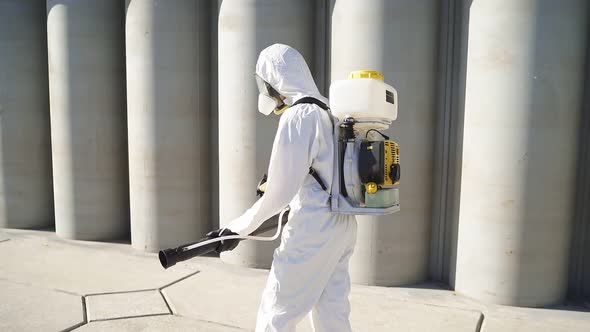 Disinfector in Protective Suit Processes Territory of Streets, Sprays Poison From Pests.