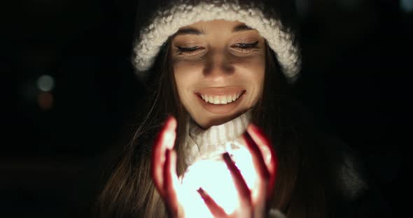 Girl Unfolding Hands Filled with Small Decoration Lights