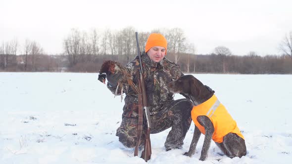 Positive Hunter with Dogs During the Rest on Winter Hunting