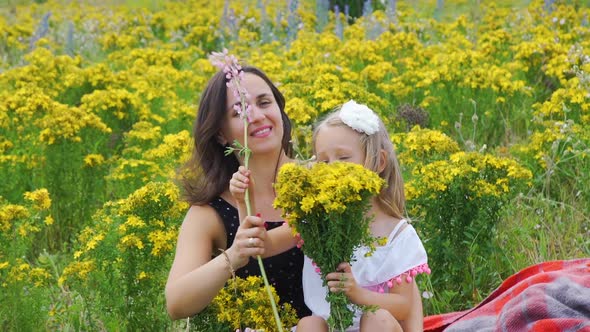 Little Girl with Mom Making a Bouquet in a Field