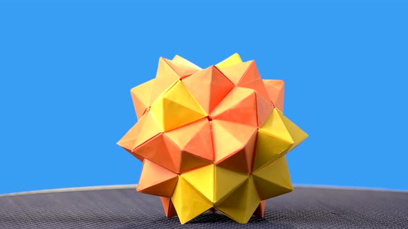 Yellow Origami Ball on Blue Background.