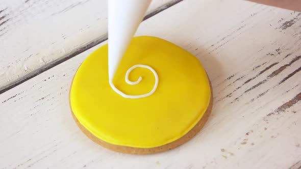 Piping a Pattern on Round Yellow Cookie