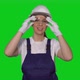 Woman Builder in Blue Overalls and White Hard Hat Put on Protective Glasses - VideoHive Item for Sale
