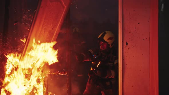 Firefighter Helping To Extinguish Fire in Burning House.