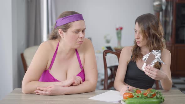 Young Slim Woman Controls Diet of Obese Caucasian Plussize Lady