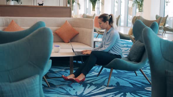 A Woman is Working Remotely From a Cafe