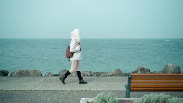 Woman Walks on Embankment Along Lake Garda on Cloudy Day