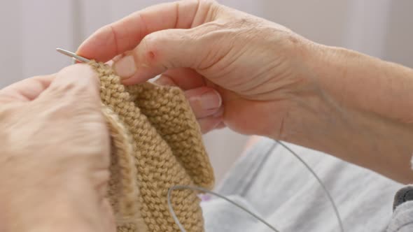 Knitting Warm Clothes Closeup Hands are Covered with Wrinkles and Agerelated Skin Lesions