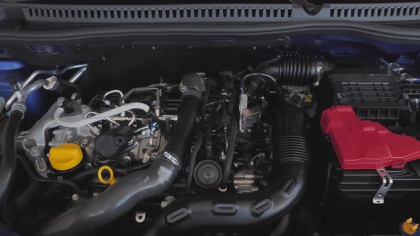 Details of Modern Car Engine in Opened Hood of Car in Service or Repair Shop