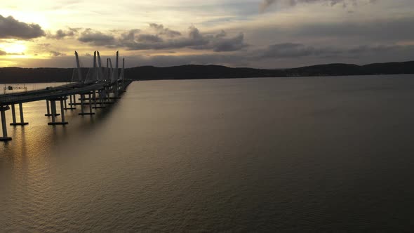 An aerial view of the Mario M. Cuomo Bridge as the drone camera truck left. The setting sun shines o