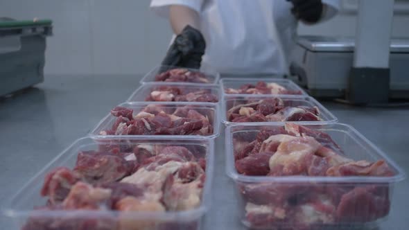 Worker in Black Proective Gloves Prepares Fresh Meat for Delivery to Stores