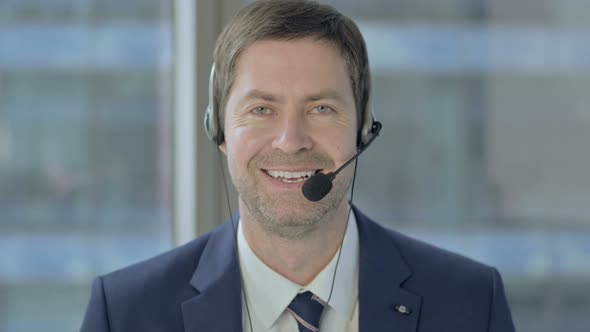 Businessman with Headset Smiling and Looking at Camera