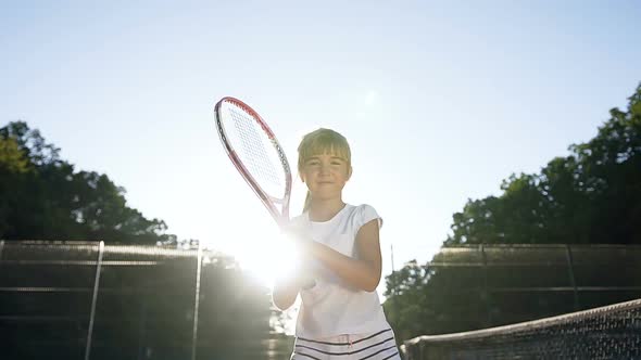 Little Girl with Tennis Racket Walking on the Court