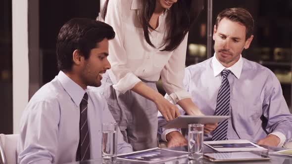 Businesswoman discussing with colleagues over digital tablet