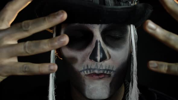 Man in Skeleton Halloween Cosplay Costume. Guy in Creepy Skull Makeup Looking Wide Open Eyes