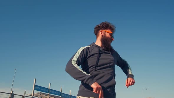 Portrait Hipster Male Dancing in Street Looking To Camera