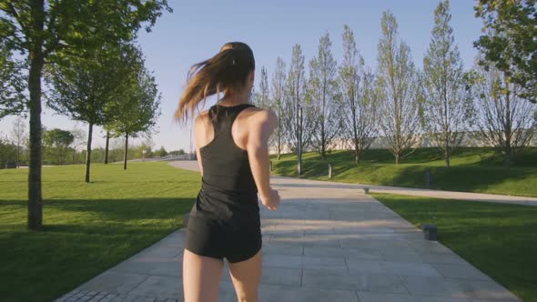 Sports Woman Makes Morning Jog and Physical Exercises In  Park