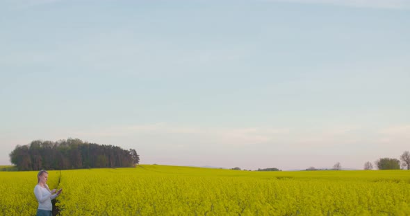 Female Farmer Examining Oilseed Rape Field