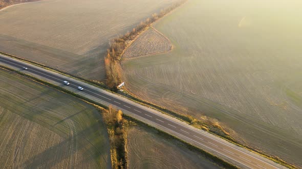 Aerial View of Intercity Road with Fast Driving Cars at Sunset