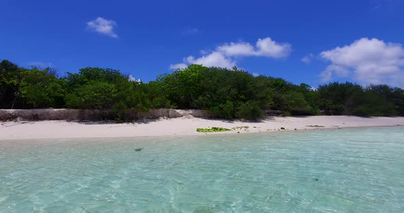 Wide angle above travel shot of a white sand paradise beach and aqua blue ocean background in hi res