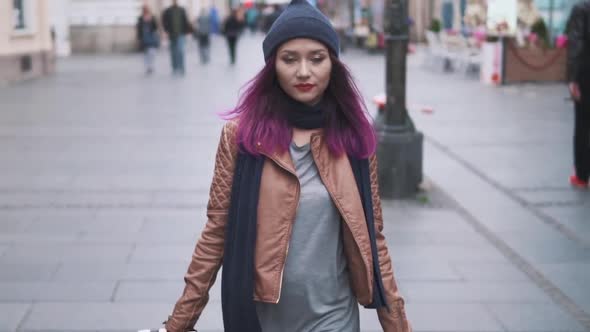 Attractive Young Woman Traveler Walk Through the City Street with Luggage in Hands. Hipster Girl