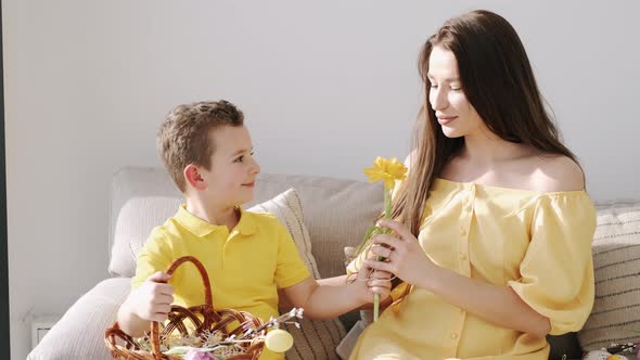Pretty Young Mother in Yellow Dress Sitting with Kids on Coach on Easter