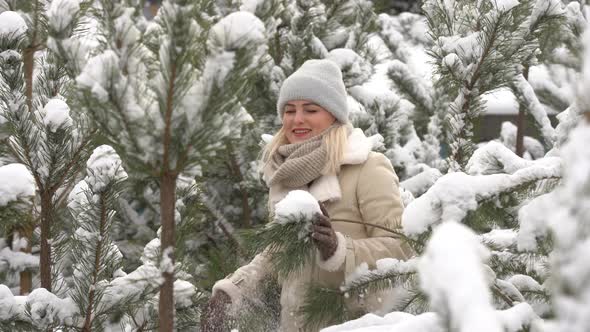 Beautiful Woman Standing Among Snowy Trees in Winter Forest and Enjoying First Snow