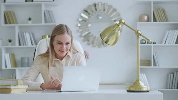 Beautiful woman talking on live video with colleagues using laptop