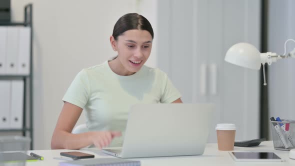 Young Latin Woman with Laptop Celebrating Success 