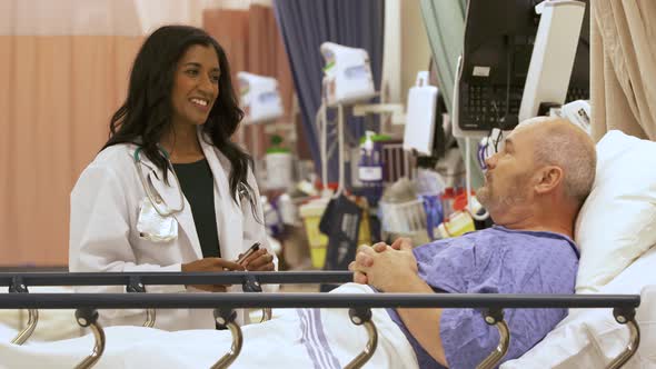 Doctor with a friendly bedside manner talks to patient in hospital.