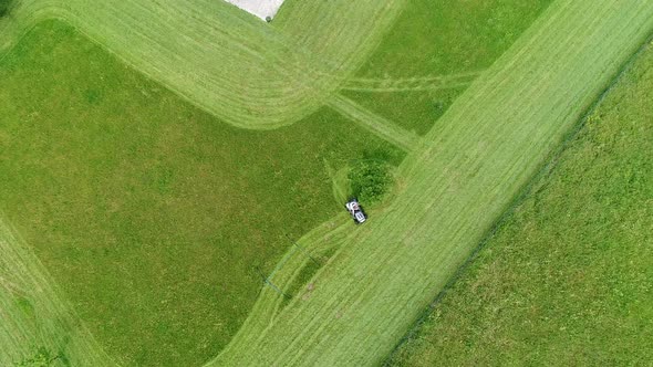 Riding lawn mower in action seen from the sky