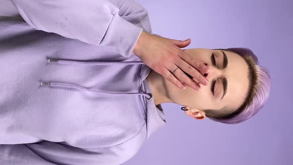 Vertical Young Adult Woman Yawning Shuddering on Purple Background