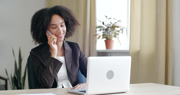 Young Friendly Business Woman Consultant Wearing Blazer Jacket, Sitting in Cozy Office at Home